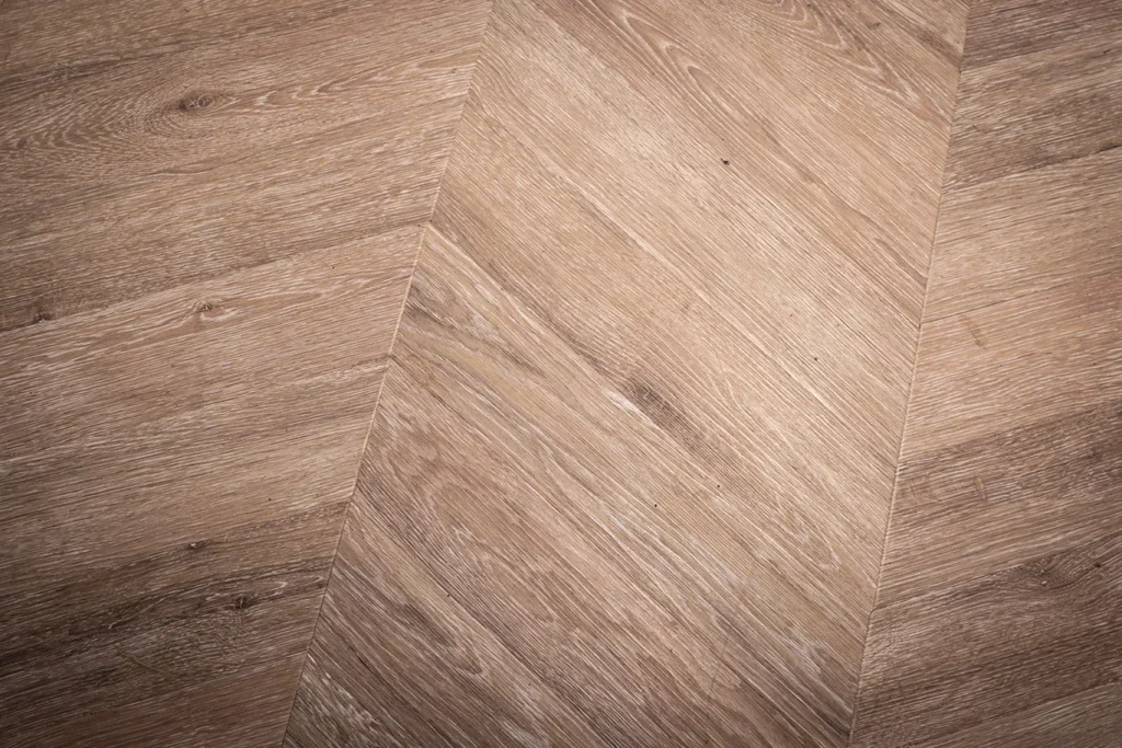 Warmes Parkettbodenmuster in Fischgrätverlegung