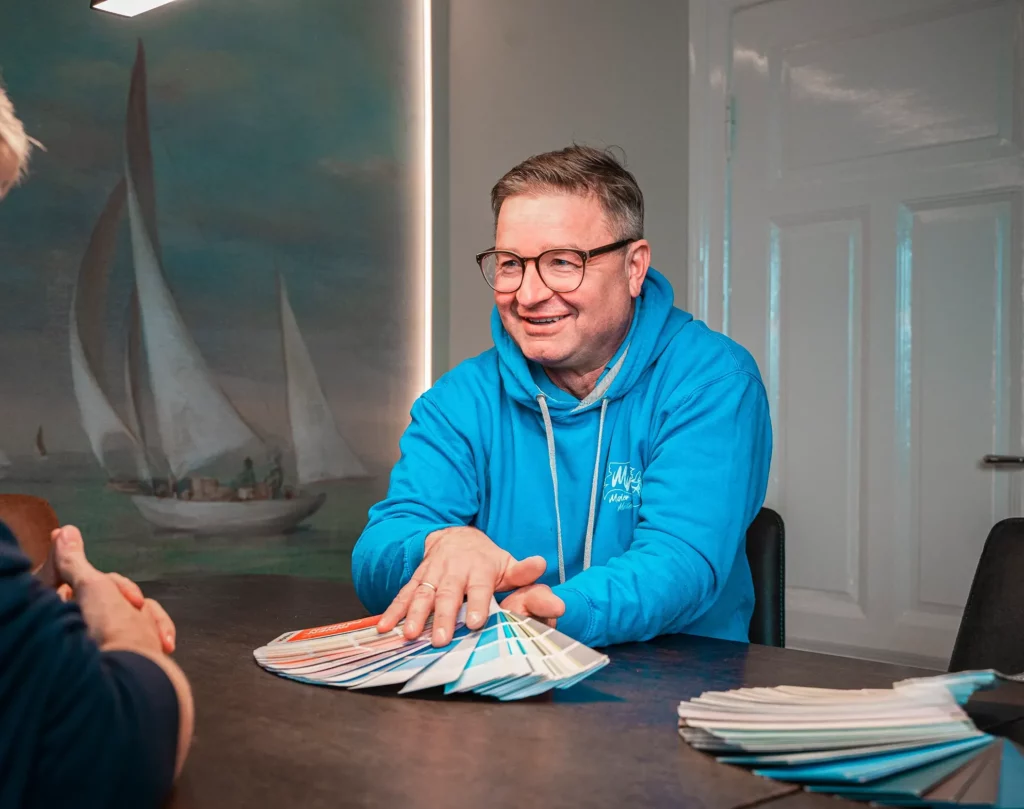 Fröhlicher Geschäftsführer beim Beratungsgespräch