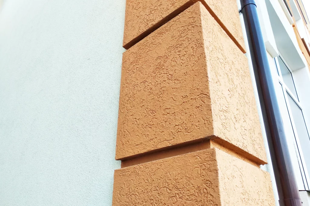 Nahaufnahme eines strukturierten Außenputzes in Terrakotta